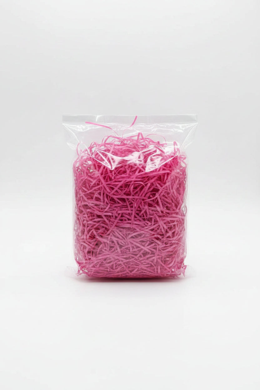Pink fuchsia shredded paper gift box filler in a clear bag
