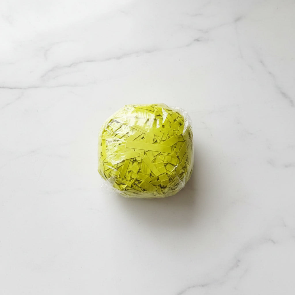 Yellow green lime shredded paper gift box filler in a clear bag