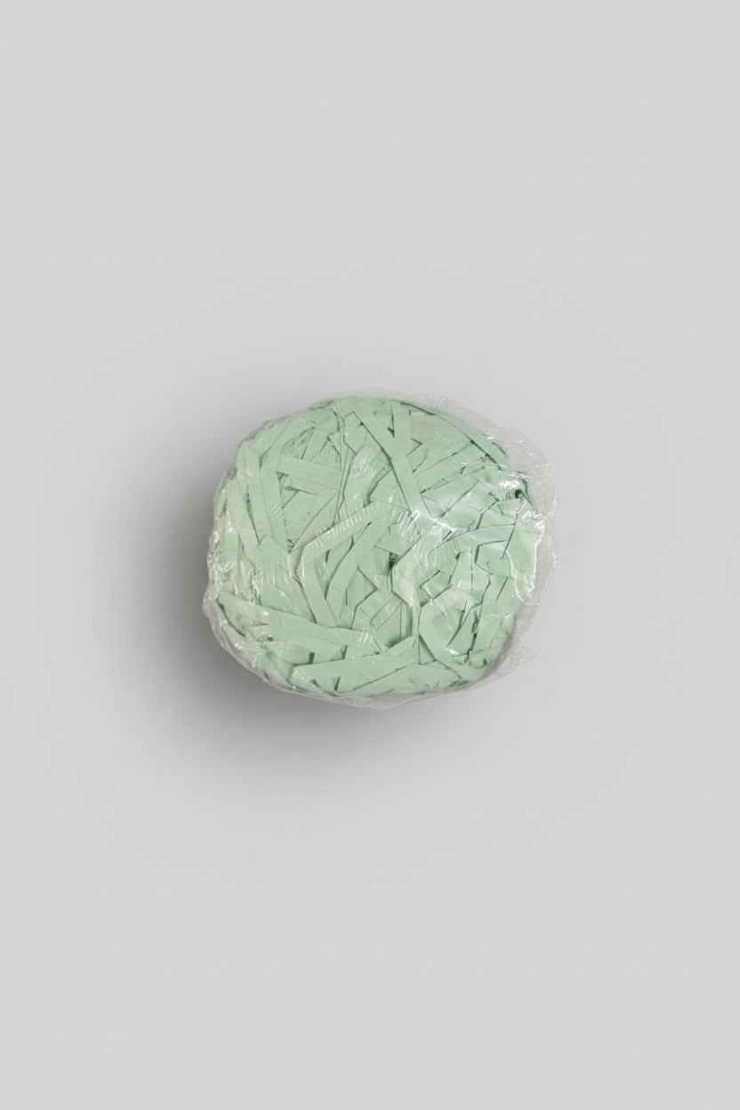 Mint green shredded paper gift box filler in a clear bag