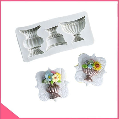White silicone mould with brown, lavender and blue cast urn outputs and flower cake decoration