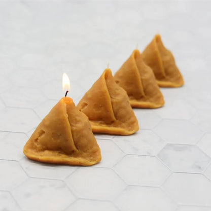 Samosa candle styled with cinnamon sticks, star anise, and cloves next to a chai candle in a glass