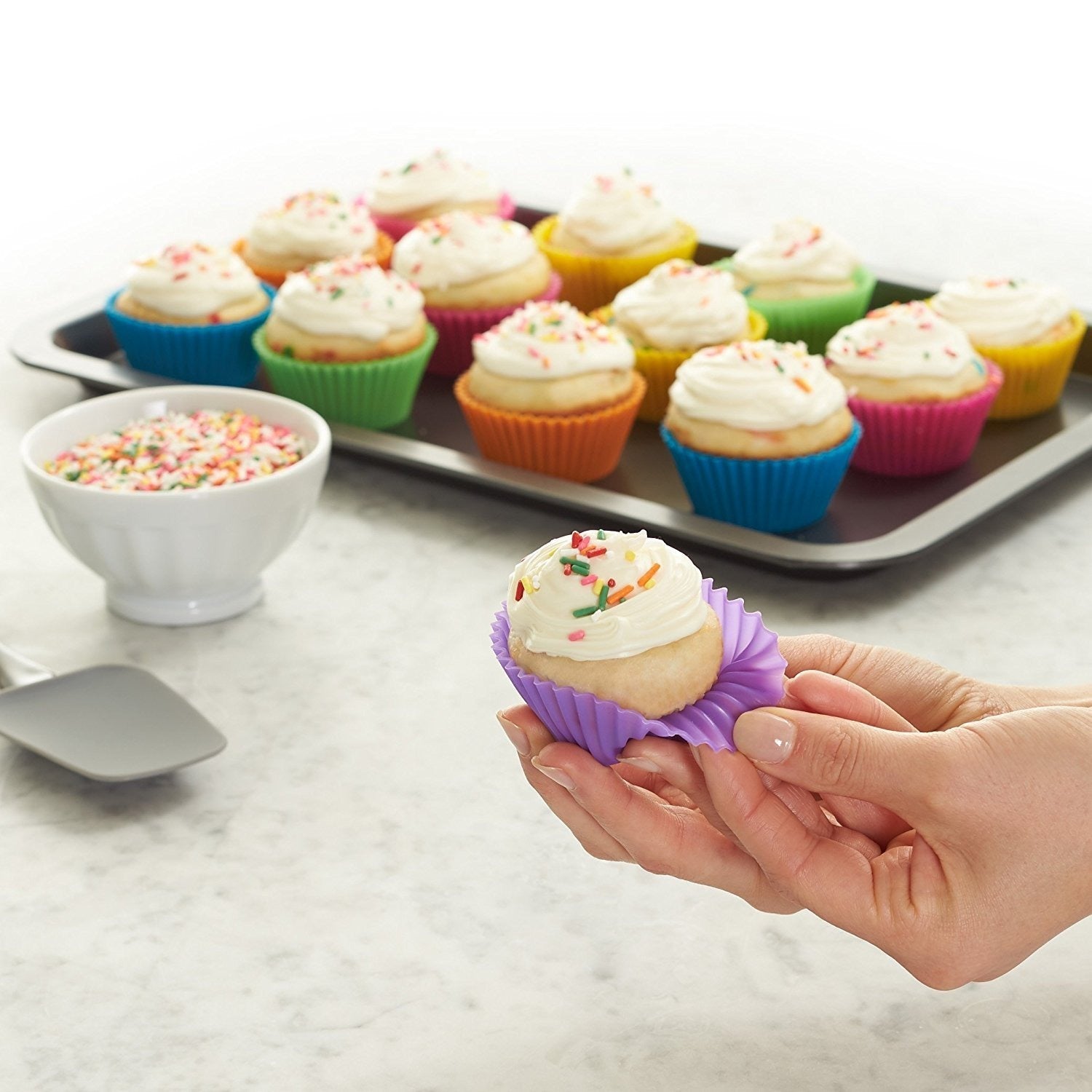 Cupcakes baked in colourful silicone molds on a baking tray