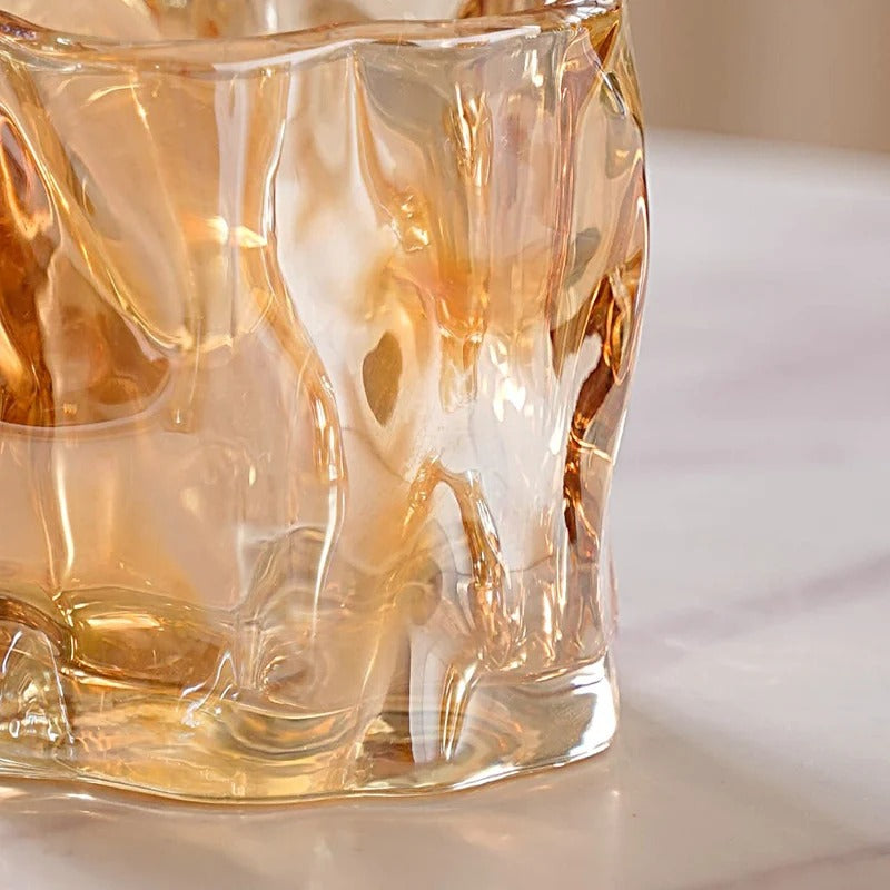 Two amber crinkle glass candle jars angled view on marble surface