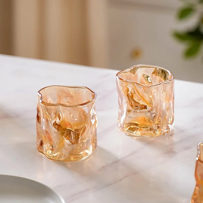 Set of 6 amber crinkle glass candle jars arranged on marble surface, luxury home interior