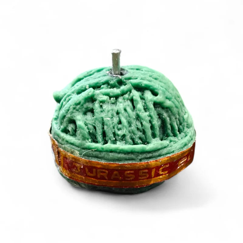 Sutli Bomb Firecracker Candle – side view showing Jurassic Bomb label and dome rope texture in dark green wax
