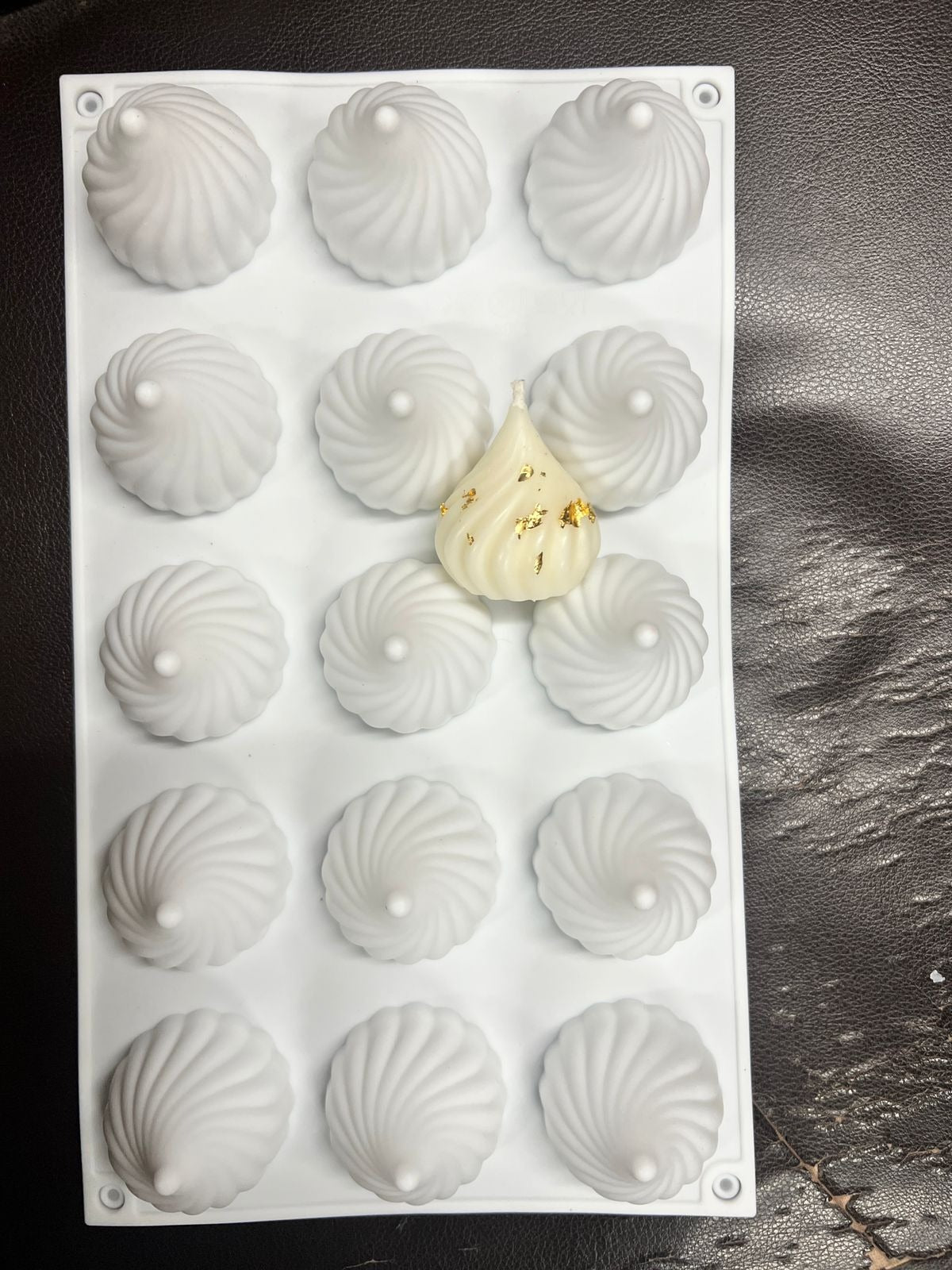 Handmade white modak candle with gold foil accents made using the modak mould