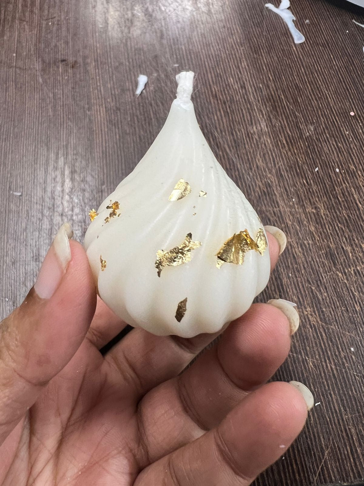 Modak silicone mould tray with a finished white gold-foil modak candle in the centre