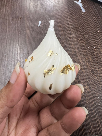 Modak silicone mould tray with a finished white gold-foil modak candle in the centre