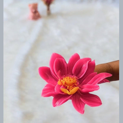 Lotus flower silicone mould in pink with finished pink wax lotus casting displayed beside it