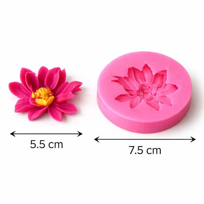 Hand holding a vibrant pink multi-petal lotus wax candle with yellow centre, made using the mould