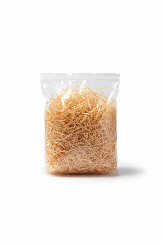 Golden peach shredded wooden gift box filler in a clear bag