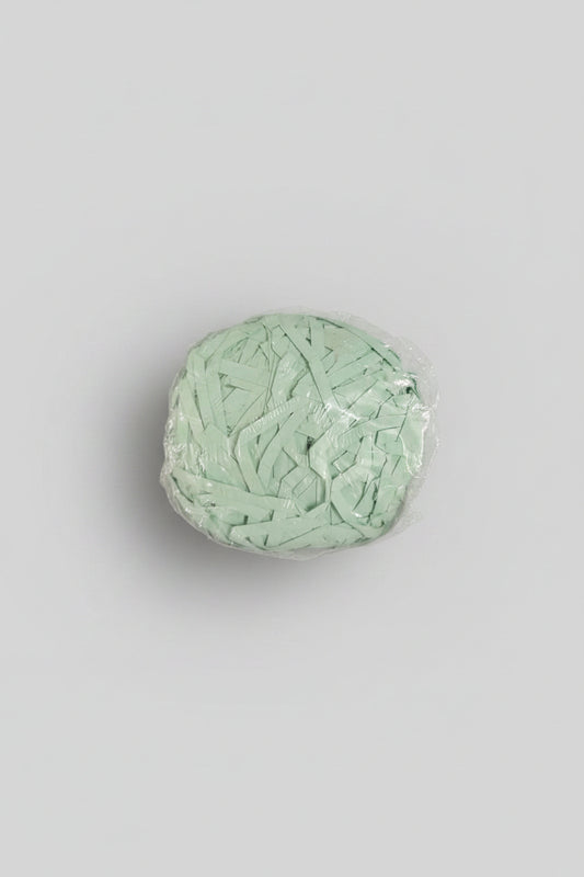 Mint green shredded paper gift box filler in a clear bag