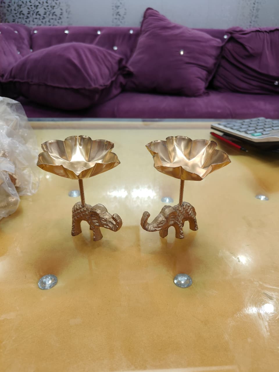 Pair of copper gold tall stem elephant lotus bowl diya holders, angled view