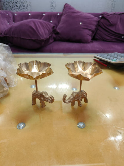 Pair of copper gold tall stem elephant lotus bowl diya holders, angled view