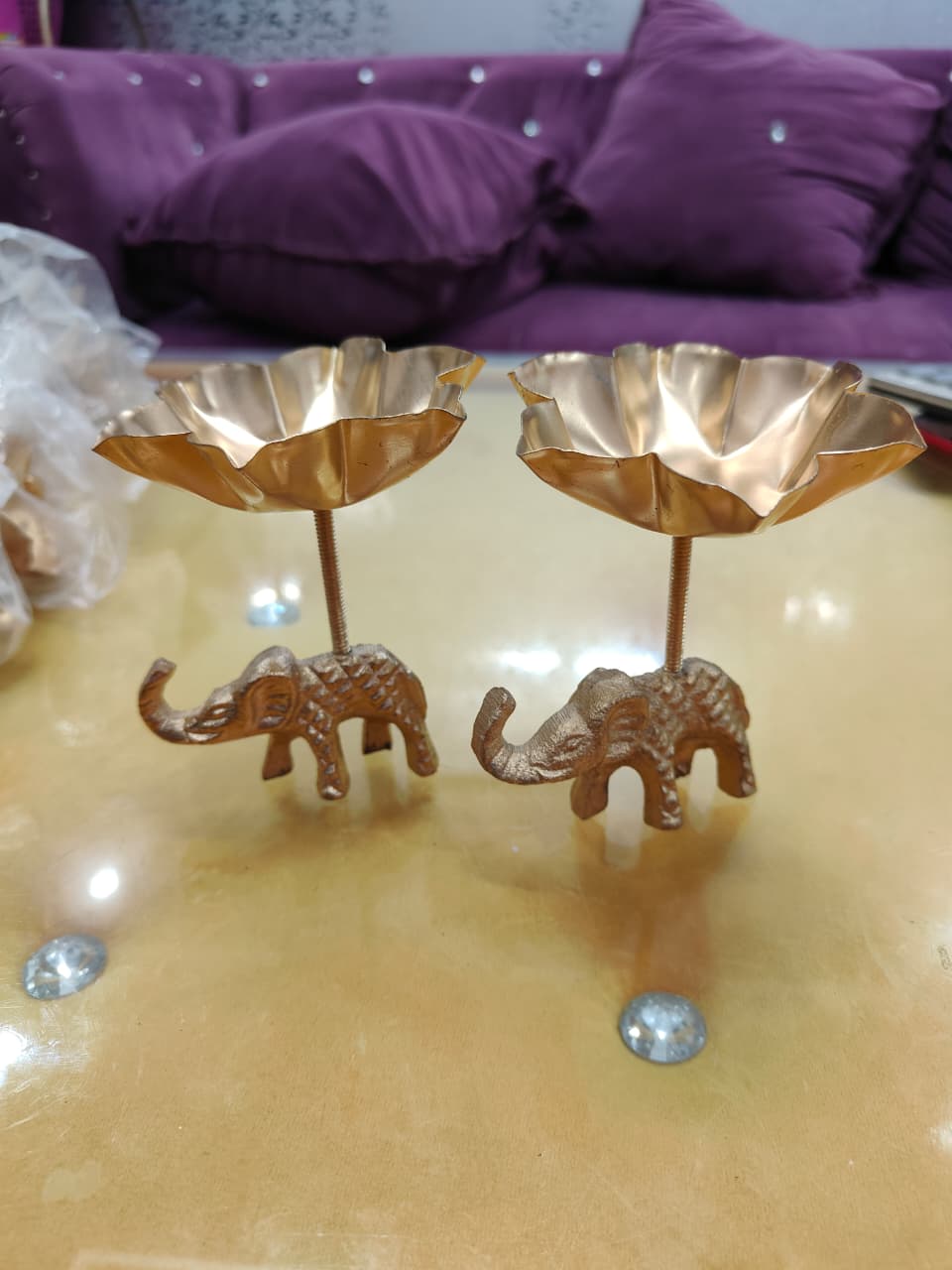 Pair of copper gold tall stem elephant lotus bowl diya holders, close-up view