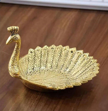 Gold metal peacock decorative tray with intricate feather etching and 3D peacock head with crown, on wooden surface