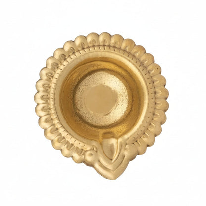 Gold metal kuber diya with traditional round scalloped edge, raised centre dome and spout, top view on white background