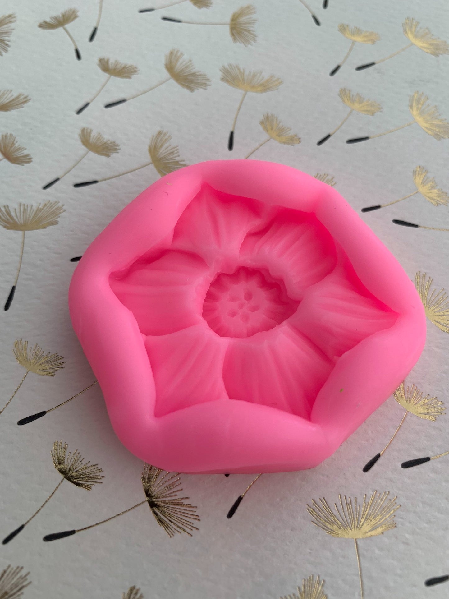 Ivory wax narcissus flower casting made from the mould, displayed on iridescent surface