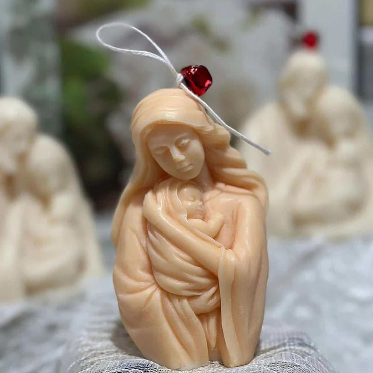 Mother-and-baby sample casting decorated with a hanging cord and red bell; accessories not included