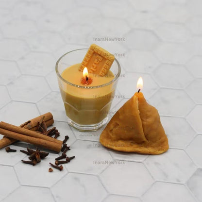 Row of golden samosa-shaped candles on marble surface, first one lit – Samosa Silicone Candle Mould