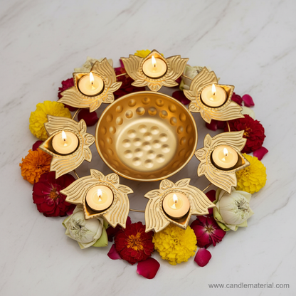 Gold lotus diya urli with 8 lit lotus diyas on marble surface with marigold and lotus flowers