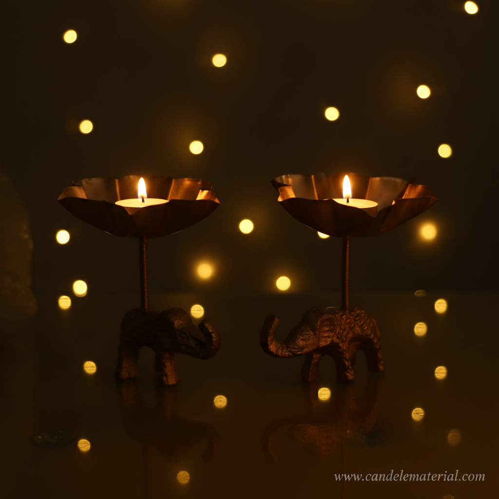 Elephant tall stem lotus diya holders with lit candles, fairy light bokeh