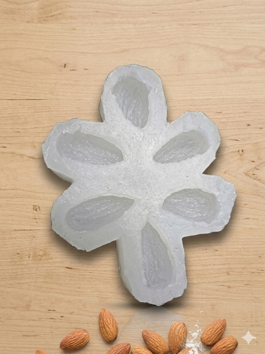 Badam Almond Candle Silicone Mold by Bloom Creations – 6-cavity white mold with real almonds displayed below on wooden surface