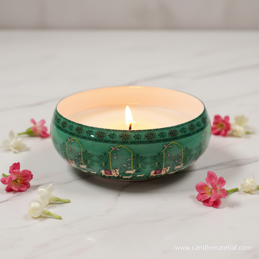 Mughal green candle bowl with lit candle on marble surface with pink flowers