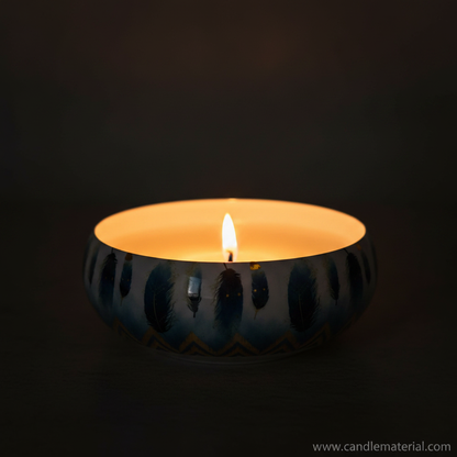 Blue feather candle bowl with lit candle, dark moody background