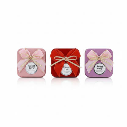 All three Sweet Love ribbon bow candle tin variants in a row on white studio background