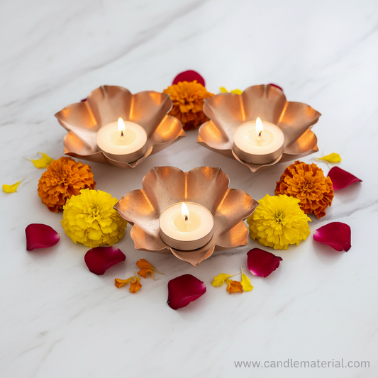 Lotus petal diya bowls with lit candles on marble surface with marigolds