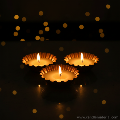 Scalloped diya bowls with lit candles, dark moody background with bokeh
