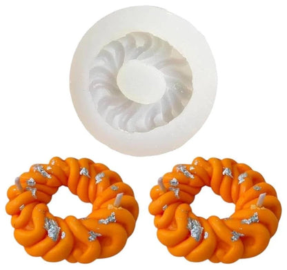Imarti silicone mould with orange twisted ring candles and silver leaf